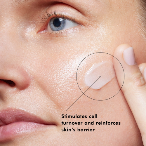 Close-up of a person applying a skincare product to their face with text indicating benefits.