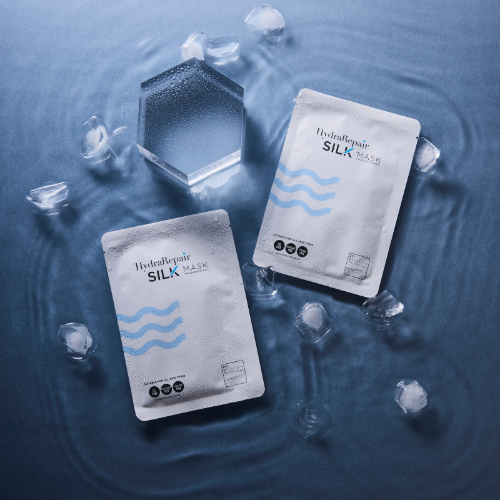 Hydra Repair Silk Mask packages on a water surface with ice cubes