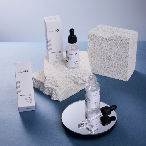 EST Skincare Serum O including bottles, boxes, and a sponge on a blue surface.