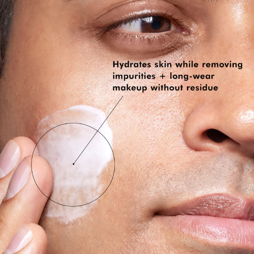 Close-up of a person applying a skincare product to their face with text about product benefits.