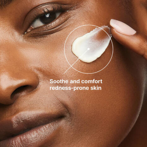 Close-up of a person applying cream to their skin with text 'Soothe and comfort redness-prone skin'.